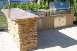 A small light-colored outdoor granite bar facing a grill.