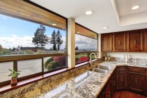 A beautiful granite kitchen countertop facing a window.
